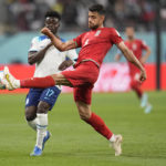 
              Iran's Morteza Pouraliganji, right, kicks the ball past England's Bukayo Saka during the World Cup group B soccer match between England and Iran at the Khalifa International Stadium in Doha, Qatar, Monday, Nov. 21, 2022. (AP Photo/Abbie Parr)
            
