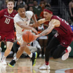 Miami guard Isaiah Wong (2) and Rutgers Caleb McConnell (22) go after the ball during the second half of an NCAA college basketball game, Wednesday, Nov. 30, 2022, in Coral Gables, Fla. (AP Photo/Marta Lavandier)