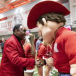 Johnny Rodgers, left, a 1972 Heisman Trophy-winning Nebraska football player, shakes hands with the Herbie Husker mascot while awaiting the start of an introductory press conference for new Nebraska NCAA college football coach Matt Rhule on Monday, Nov. 28, 2022, in Lincoln, Neb. (AP Photo/Rebecca S. Gratz)