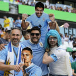 Uruguay soccer fans pose for a picture holding images of Uruguay's players Luis Suarez, above, and Darwin Nunez prior to the World Cup group H soccer match between Uruguay and South Korea, at the Education City Stadium in Al Rayyan , Qatar, Thursday, Nov. 24, 2022. (AP Photo/Martin Meissner)