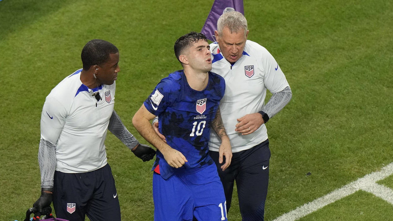 Christian Pulisic of the United States is helped by team doctors after he scoring his side's openin...