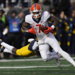 Illinois wide receiver Brian Hightower (7) evades Michigan defensive back Rod Moore (19)in the first half of an NCAA college football game in Ann Arbor, Mich., Saturday, Nov. 19, 2022. (AP Photo/Paul Sancya)