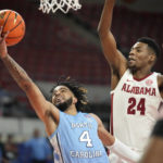 North Carolina guard R.J. Davis (4) goes to the basket as Alabama forward Brandon Miller (24) defends during the first half of an NCAA college basketball game in the Phil Knight Invitational on Sunday, Nov. 27, 2022, in Portland, Ore. (AP Photo/Rick Bowmer)