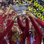 
              Switzerland's players Simona Waltert, Viktorija Golubic, Jil Teichmann, Belinda Bencic and Switzerland team captain Heinz Guenthardt, from left, celebrate with the trophy after defeating Australia to win the Billie Jean King Cup tennis finals, at the Emirates Arena in Glasgow, Scotland, Sunday, Nov. 13, 2022. (AP Photo/Kin Cheung)
            