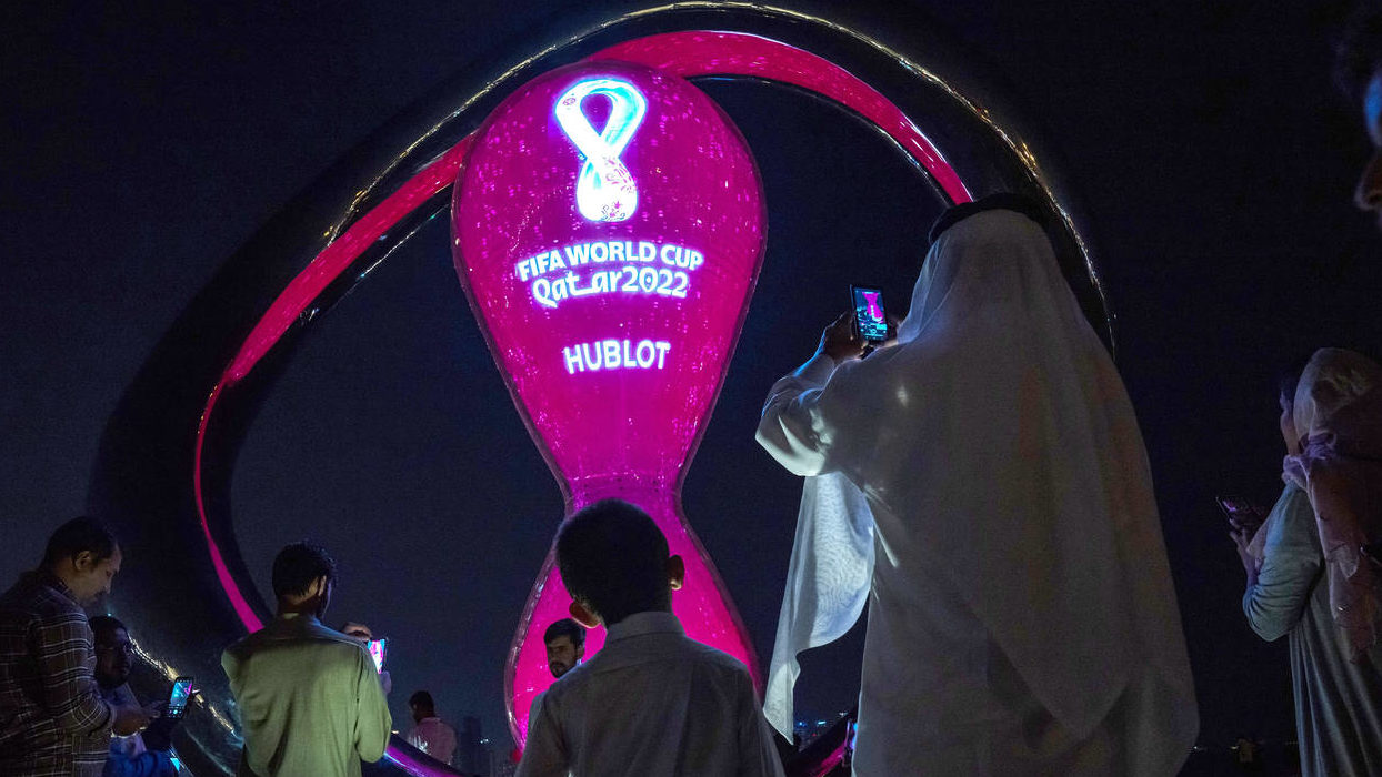 People take photos with the official FIFA World Cup Countdown Clock on Doha's corniche, in Qatar, F...