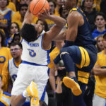 
              Pittsburgh's Nelly Cummings (0) shoots as West Virginia's Mohamed Wague, right, defends during the first half of an NCAA college basketball game, Friday, Nov. 11, 2022, in Pittsburgh. (AP Photo/Keith Srakocic)
            