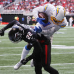 Los Angeles Chargers wide receiver DeAndre Carter (1) dives for extra yardage over Atlanta Falcons cornerback Cornell Armstrong (22) after catching a pass during the first half of an NFL football game, Tuesday, Dec. 6, 2022, in Atlanta. (AP Photo/Butch Dill)