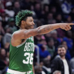Boston Celtics guard Marcus Smart points to teammates after a basket during the second half of an NBA basketball game against the Detroit Pistons, Saturday, Nov. 12, 2022, in Detroit. (AP Photo/Carlos Osorio)