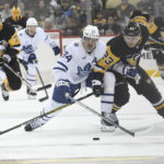 Pittsburgh Penguins left wing Brock McGinn (23) and Toronto Maple Leafs center Auston Matthews go for the puck during the second period of a hockey game, Saturday, Nov. 26, 2022, in Pittsburgh. (AP Photo/Philip G. Pavely)