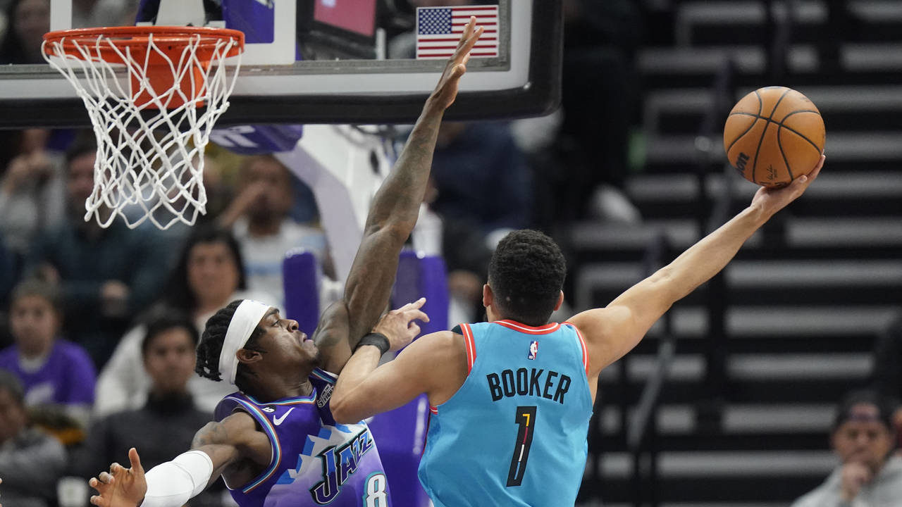 Phoenix Suns guard Devin Booker (1) goes to the basket as Utah Jazz forward Jarred Vanderbilt (8) d...