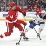 Detroit Red Wings left wing David Perron (57) shoots and scores as Buffalo Sabres left wing Jeff Skinner (53) defends in the third period of an NHL hockey game Wednesday, Nov. 30, 2022, in Detroit. (AP Photo/Paul Sancya)