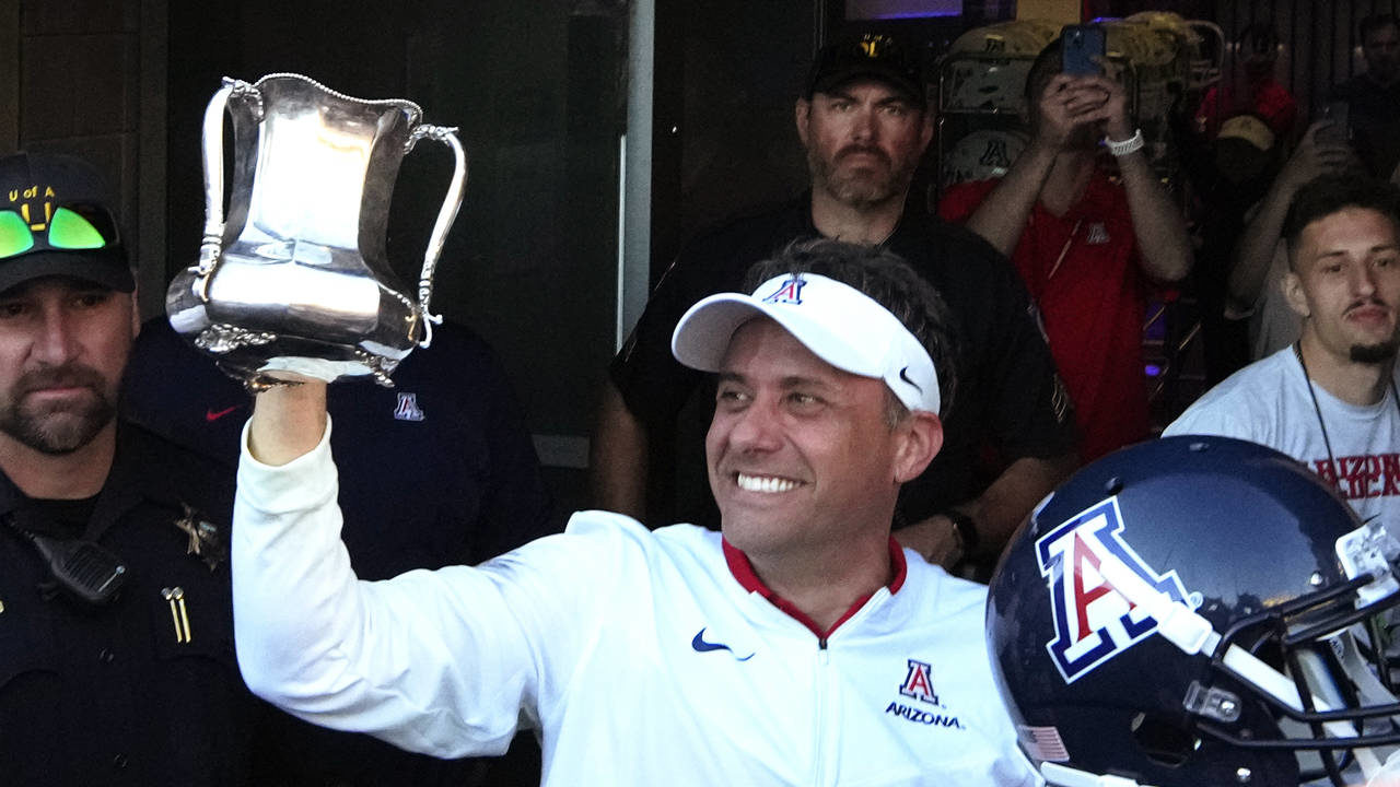 Arizona coach Jedd Fisch holds up the Territorial Cup after the team's 38-35 win over Arizona durin...