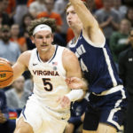 
              Virginia's Ben Vander Plas (5) drives with the ball against Monmouth during the first half of an NCAA college basketball game in Charlottesville, Va., Friday, Nov. 11, 2022. (AP Photo/Mike Kropf)
            