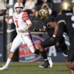 
              Utah quarterback Cameron Rising, left, looks to pass the ball as Colorado linebacker Marvin Ham II pursues in the first half of an NCAA college football game Saturday, Nov. 26, 2022, in Boulder, Colo. (AP Photo/David Zalubowski)
            
