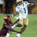 UCLA quarterback Dorian Thompson-Robinson (1) gets stopped by Arizona State defensive back Khoury Bethley (15) during the second half of an NCAA college football game in Tempe, Ariz., Saturday, Nov. 5, 2022. UCLA won 50-36. (AP Photo/Ross D. Franklin)
