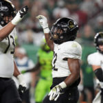 UCF running back RJ Harvey (22) celebrates with offensive lineman Samuel Jackson (73) after scoring on a 3-yard touchdown run against South Florida during the first half of an NCAA college football game Saturday, Nov. 26, 2022, in Tampa, Fla. (AP Photo/Chris O'Meara)