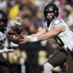 
              Oregon quarterback Bo Nix, right, hands off the ball to running back Noah Whittington in the first half of an NCAA college football game against Colorado, Saturday, Nov. 5, 2022, in Boulder, Colo. (AP Photo/David Zalubowski)
            