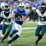 Indianapolis Colts running back Jonathan Taylor (28) runs past Philadelphia Eagles cornerback James Bradberry (24) and safety C.J. Gardner-Johnson (23) in the first half of an NFL football game in Indianapolis, Sunday, Nov. 20, 2022. (AP Photo/AJ Mast)