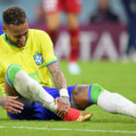 Brazil's Neymar grabs his ankle after an injury during the World Cup group G soccer match between Brazil and Serbia, at the the Lusail Stadium in Lusail, Qatar on Thursday, Nov. 24, 2022. (Laurent Gillieron/Keystone via AP)