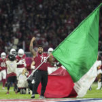 Arizona Cardinals offensive lineman Will Hernandez waves the flag of Mexico before an NFL football game against the San Francisco 49ers, Monday, Nov. 21, 2022, in Mexico City. (AP Photo/Marcio Jose Sanchez)