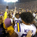 LSU offensive lineman Fitzgerald West Jr. (68) and linebacker DeMario Tolan (32) celebrate with fans who stormed the field after an NCAA college football game against Alabama in Baton Rouge, La., Saturday, Nov. 5, 2022. (AP Photo/Tyler Kaufman)