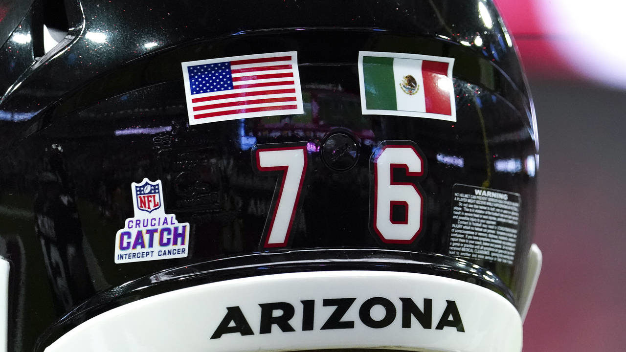 Arizona Cardinals' Will Hernandez wears a United States flag and a Mexican flag on his helmet befor...