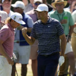 
              FILE - Scottie Scheffler pumps his fist as walks past Cameron Smith, of Australia, after a birdie chip on the third hole during the final round at the Masters golf tournament on Sunday, April 10, 2022, in Augusta, Ga. The hole was the turning point in Scheffler winning the Masters this year. (AP Photo/Robert F. Bukaty, File)
            