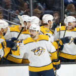 Nashville Predators forward Filip Forsberg is congratulated by teammates on the bench after scoring a goal during the second period of an NHL hockey game against the Seattle Kraken, Tuesday, Nov. 8, 2022, in Seattle. (AP Photo/Stephen Brashear)
