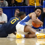 
              Pittsburgh's Nelly Cummings, right, tries to control the ball from the floor in front of West Virginia's Kedrian Johnson, left, during the first half of an NCAA college basketball game, Friday, Nov. 11, 2022, in Pittsburgh. (AP Photo/Keith Srakocic)
            