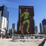 
              A construction cite is seen in front of a building with a Germany's goalkeeper Manuel Neuer's portrait in Lusail downtown, Qatar, Thursday, Nov. 24, 2022. (AP Photo/Pavel Golovkin)
            