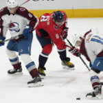Washington Capitals left wing Alex Ovechkin (8) reaches for the puck from between Colorado Avalanche defenseman Erik Johnson (6) and center Andrew Cogliano (11) during the third period of an NHL hockey game Saturday, Nov. 19, 2022, in Washington. The Avalanche won 4-0. (AP Photo/Jess Rapfogel)