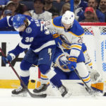 
              Tampa Bay Lightning left wing Brandon Hagel (38) tries to deflect the puck past Buffalo Sabres defenseman Lawrence Pilut (20) and goaltender Eric Comrie (31) during the first period of an NHL hockey game Saturday, Nov. 5, 2022, in Tampa, Fla. (AP Photo/Chris O'Meara)
            