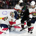 Florida Panthers goaltender Spencer Knight, left, makes a save on a shot by Arizona Coyotes right wing Clayton Keller (9) as Panthers defensemen Brandon Montour (62) and Gustav Forsling (42) pressure Keller during the third period of an NHL hockey game in Tempe, Ariz., Tuesday, Nov. 1, 2022. The Coyotes won 3-1. (AP Photo/Ross D. Franklin)