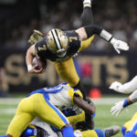 New Orleans Saints' Taysom Hill (7) is tripped up by Los Angeles Rams defenders in the first half of an NFL football game in New Orleans, Sunday, Nov. 20, 2022. (AP Photo/Gerald Herbert)