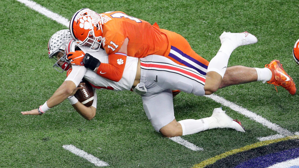 Justin Fields #1 of the Ohio State Buckeyes is tackled by Bryan Bresee #11 of the Clemson Tigers in...