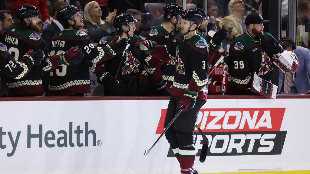 Josh Brown #3 of the Arizona Coyotes celebrates with teammates on the bench after scoring a goal ag...