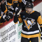 Pittsburgh Penguins' Bryan Rust (17) returns to the bench after scoring during the first period of the team's NHL hockey game against the St. Louis Blues in Pittsburgh, Saturday, Dec. 3, 2022. (AP Photo/Gene J. Puskar)