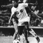 New York Cosmos forward Pelé controls the ball as Miami Toros midfielder Tommy Mulroy defends during the second half of an NASL soccer game at New York's Yankee Stadium on Aug. 10, 1976. Pelé, the Brazilian king of soccer who won a record three World Cups and became one of the most commanding sports figures of the last century, died Thursday, Dec. 29, 2022. He was 82. (AP Photo/Richard Drew, File)