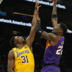 Phoenix Suns center Deandre Ayton shoots over Los Angeles Lakers center Thomas Bryant during the second half of an NBA basketball game, Monday, Dec. 19, 2022, in Phoenix. (AP Photo/Rick Scuteri)