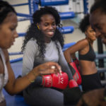 
              Boxer Legnis Cala, center, talks with fellow female boxers during a training session in Havana, Cuba, Monday, Dec. 5, 2022. Cuban officials announced on Monday that women boxers would be able to compete for the first time ever. (AP Photo/Ramon Espinosa)
            