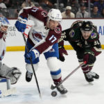 Colorado Avalanche defenseman Brad Hunt (17) and Arizona Coyotes right wing Christian Fischer (36) compete for the puck in front of Avalanche goaltender Alexandar Georgiev, left, during the third period of an NHL hockey game in Tempe, Ariz., Tuesday, Dec. 27, 2022. The Coyotes won 6-3. (AP Photo/Ross D. Franklin)