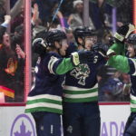 Vancouver Canucks' Brock Boeser, Ilya Mikheyev and Elias Pettersson celebrate Boeser's goal against the Arizona Coyotes during the third period of an NHL hockey game Saturday, Dec. 3, 2022, in Vancouver, British Columbia. (Darryl Dyck/The Canadian Press via AP)