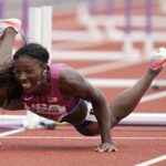 
              Nia Ali, of the United States, falls while competing in a heat in the women's 100-meter hurdles at the World Athletics Championships on Saturday, July 23, 2022, in Eugene, Ore. (AP Photo/Ashley Landis)
            