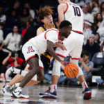 
              California's Devin Askew (55) runs into a screen set by Arizona's Azuolas Tubelis (10) as Courtney Ramey (0) dribbles around him during the first half of an NCAA college basketball game, Sunday, Dec. 4, 2022, in Tucson, Ariz. (AP Photo/Darryl Webb)
            