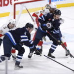 Winnipeg Jets' Morgan Barron (36) and Saku Maenalanen (8) reach to deflect an incoming shot as Florida Panthers' Matt Kiersted (3) and Marc Staal (18) defend during the first period of an NHL hockey game Tuesday, Dec. 6, 2022, in Winnipeg, Manitoba. (Fred Greenslade/The Canadian Press via AP)