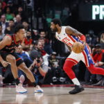 Brooklyn Nets guard Kyrie Irving (11) dribbles against Toronto Raptors forward Scottie Barnes, left, during the first half of an NBA basketball game in Toronto, Friday, Dec. 16, 2022. (Cole Burston/The Canadian Press via AP)