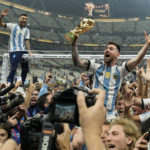 
              Argentina's Lionel Messi celebrates with the trophy in front of fans after winning the World Cup final soccer match between Argentina and France at the Lusail Stadium in Lusail, Qatar, Dec. 18, 2022. Argentina won 4-2 in a penalty shootout after the match ended tied 3-3. (AP Photo/Martin Meissner)
            