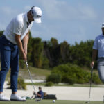
              Justin Thomas, of the United States, left, hits for par at the third green as Cameron Young, of the United States, looks on during the final round of the Hero World Challenge PGA Tour at the Albany Golf Club in New Providence, Bahamas, Sunday, Dec. 4, 2022. (AP Photo/Fernando Llano)
            