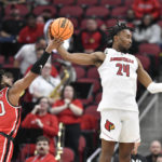 Western Kentucky guard Dayvion McKnight (20) attempts to strip the ball away from Louisville forward Jae'Lyn Withers (24) during the first half of an NCAA college basketball game in Louisville, Ky., Wednesday, Dec. 14, 2022. (AP Photo/Timothy D. Easley)