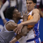 
              Seton Hall forward KC Ndefo, left, and Kansas guard Kevin McCullar Jr., right, battle for the ball during the first half of an NCAA college basketball game Thursday, Dec. 1, 2022, in Lawrence, Kan. (AP Photo/Charlie Riedel)
            